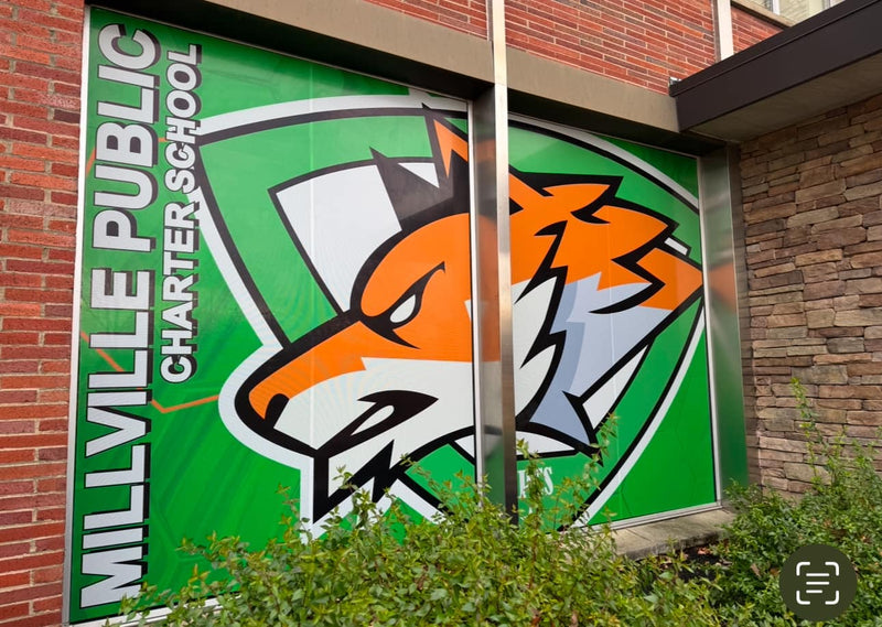 Millville Public Charter School logo on a building facade with a tiger emblem.